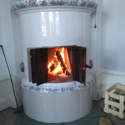 a fireplace with a fire inside of it at B&B Bjärtrå in Hjälta