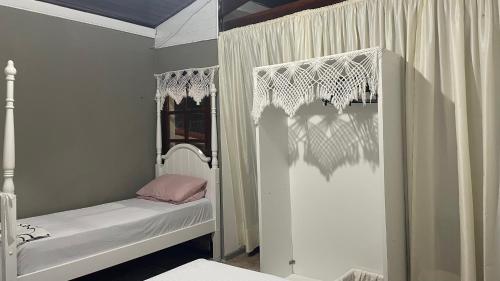 a childs bedroom with a white crib and a window at Flat ACM in Natal