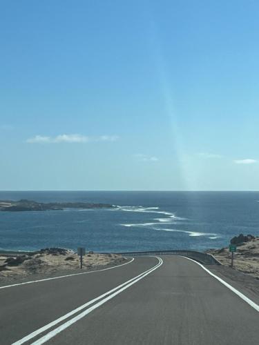 an empty road next to the ocean at descanso y paz in Caldera