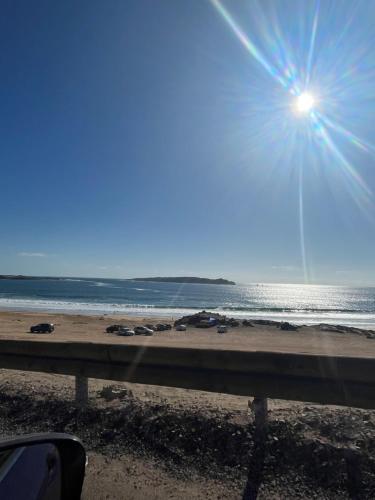 a view of a beach with a sun shining over the water at descanso y paz in Caldera