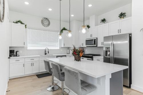 a kitchen with white cabinets and a large white island at Dream suite in downtown in Houston