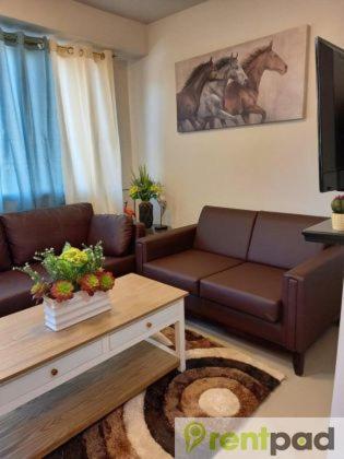 sala de estar con sofá y mesa en Fully Furnished 3 Bedroom House + Public Pool + Wi-Fi + Air conditioning en Mandaue City