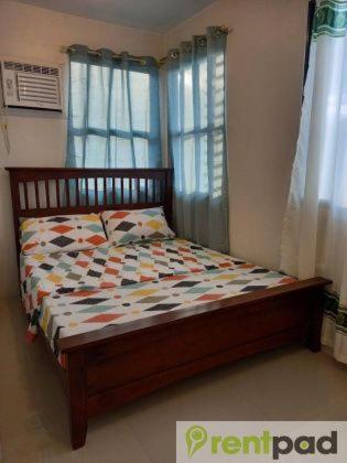 1 cama en un dormitorio con ventana en Fully Furnished 3 Bedroom House + Public Pool + Wi-Fi + Air conditioning en Mandaue City