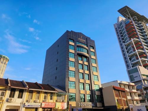 a tall building in the middle of some buildings at ZOOM HOTEL in George Town