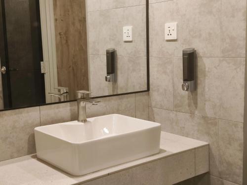 - białą umywalkę w łazience z lustrem w obiekcie ZOOM HOTEL w mieście George Town