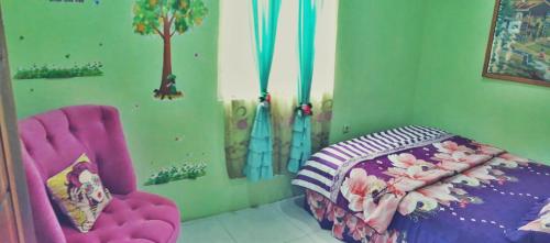a childs room with a bed and a chair at D-Rima Homestay Ruteng in Ruteng