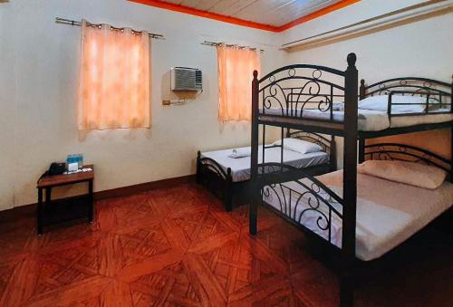 a room with two bunk beds and a table and a window at RedDoorz @ Johsons Pension House Butuan City in Butuan