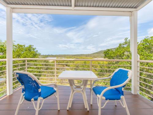 a table and chairs on a balcony with a view at Hastings Cove Holiday Apartments in Hastings Point