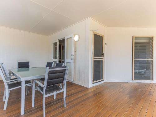 a dining room with a glass table and chairs at Hastings Cove Holiday Apartments in Hastings Point