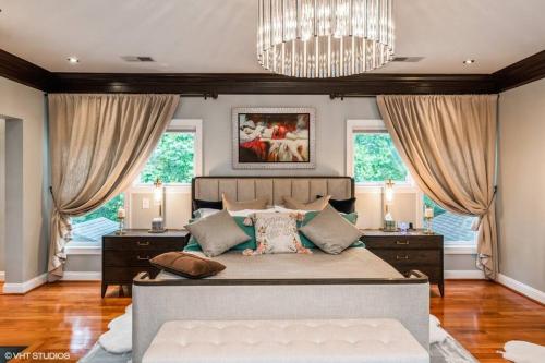 a bedroom with a large bed and two windows at Luxury Retreat with Family Feel: Perfect Getaway! in Leesburg