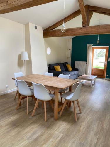 Un comedor con mesa y sillas de madera. en Gîte de Corsas, en Saint-Victor