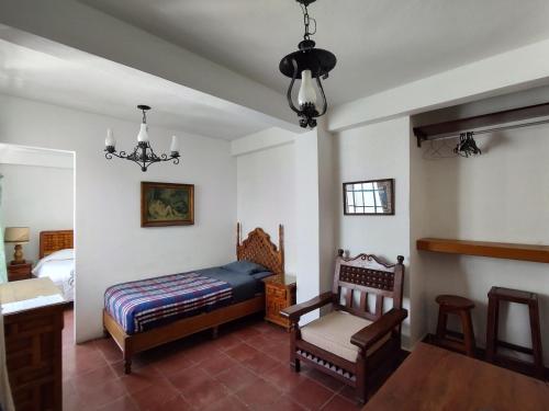 um quarto com uma cama, uma cadeira e uma mesa em Home Sweet Home em Cuernavaca