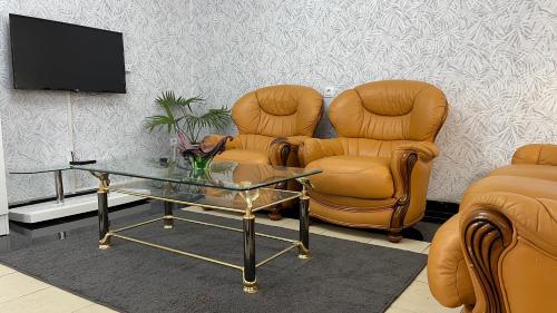 a living room with two chairs and a table and a tv at PEACE GUEST HOUSE in Yaoundé