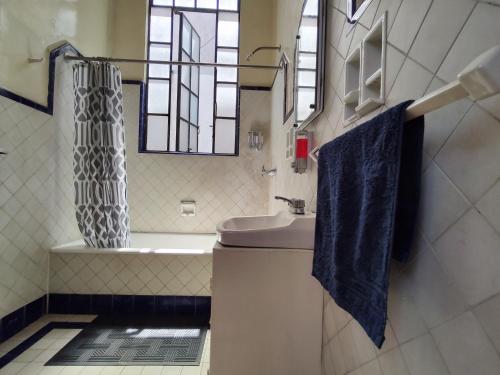 a bathroom with a sink and a shower curtain at Home Sweet Home in Cuernavaca