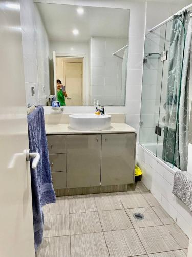 a white bathroom with a sink and a mirror at New Comfy stylish Apt in Rhodes Next to train n shopping center in Sydney