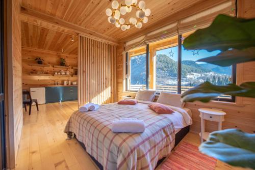 ein Schlafzimmer mit einem Bett und einem großen Fenster in der Unterkunft Svaneti Countryside 5 in Mestia