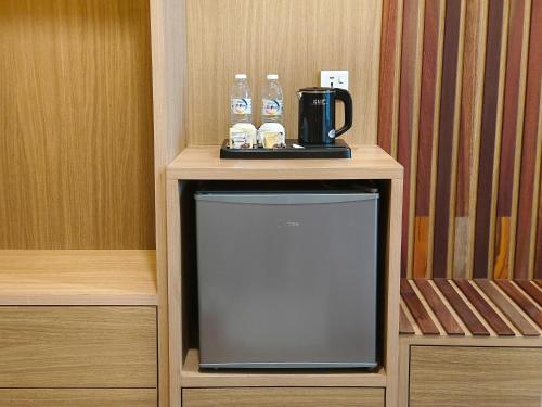 telewizor na stojaku z ekspresem do kawy i butelkami wody w obiekcie ZOOM HOTEL w mieście George Town