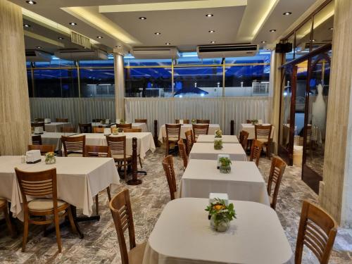 波薩里卡的住宿－Hotel Cristal，一间设有白色桌椅的用餐室