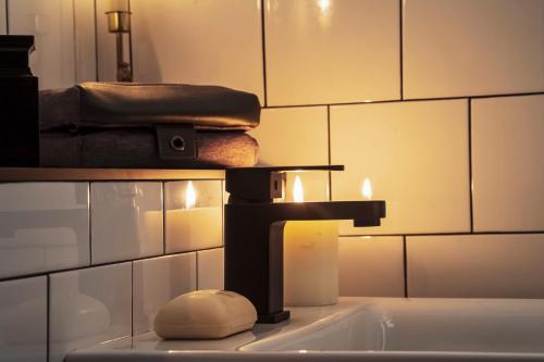 a bathroom sink with a faucet and a towel at BOHOSTEL in Macclesfield