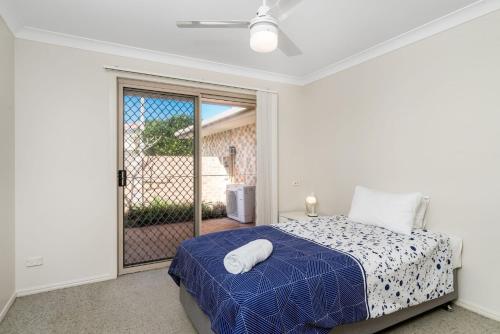 a bedroom with a bed and a sliding glass door at The Terrace in East Ballina