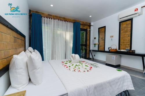 a hotel room with a bed with a white blanket at Koh Rong Hill Beach Resort in Koh Rong Island