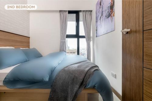 una camera da letto con un letto blu con una finestra di High Floor New Bldg 4B2bLDK Ximending, Stunning Views • 高層新樓 4房2衛 西門町 美景 a Taipei