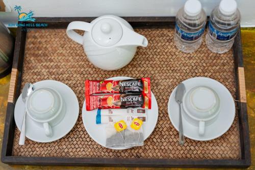 a table with plates and a tea pot and water bottles at Koh Rong Hill Beach Resort in Koh Rong Island
