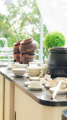 Un mostrador con platos y ollas encima. en Kapal Garden Hotel at Rekreasi Sengkaling, en Malang