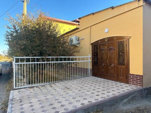 un portail en face d'une maison avec une clôture dans l'établissement Lovely home, à Ourguentch