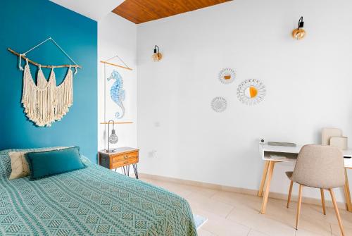 a bedroom with a bed and a desk at Boutique apartment with BBQ terrace and ocean views in Tabaiba