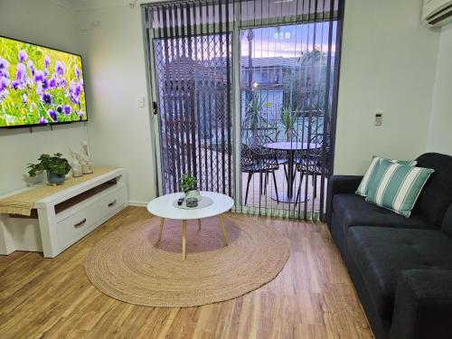 een woonkamer met een bank en een tafel bij Stay for Memories Unit 3 in Mandurah