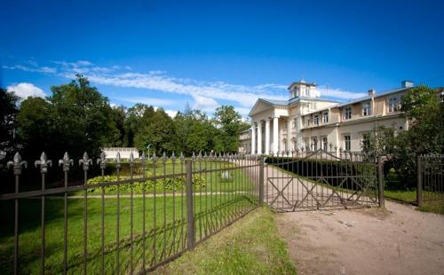 a fence in front of a large white building at Krimuldas Muiža in Sigulda