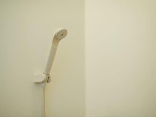 a white toothbrush hanging on a white wall at Wind City Hotel in Tahara