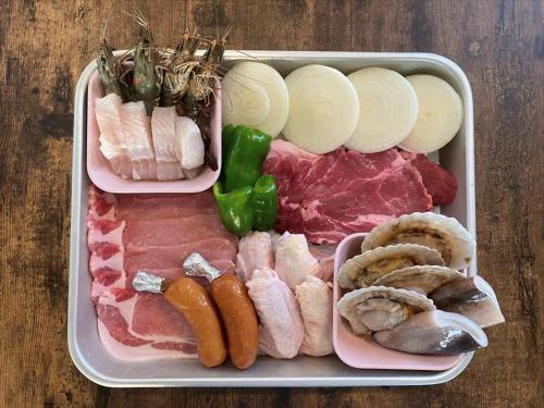 a tray of food with meat and vegetables on a table at Wood Pecker Nakijin in Nakijin