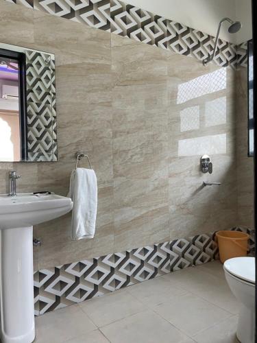 bagno con lavandino bianco e specchio di Hotel Pratap Palace a Bharatpur