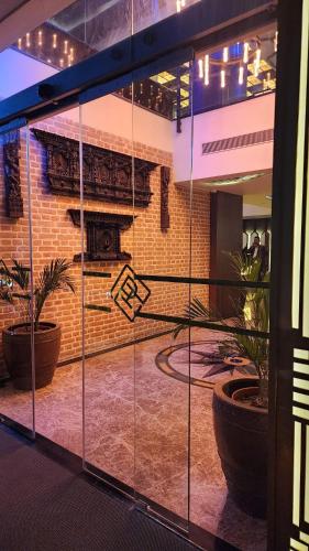 Prudential Hotel Nepal في كاتماندو: انعكس على مبنى فيه نباتات في النوافذ