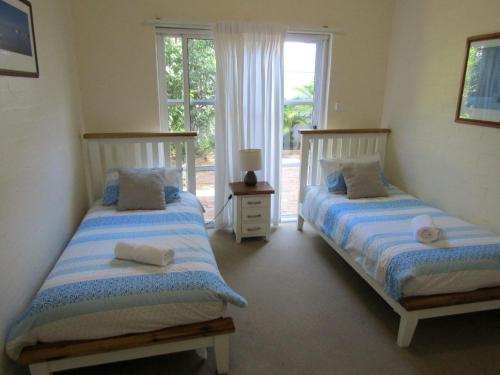 two beds in a room with a window at Quarterdeck 5 in Lennox Head