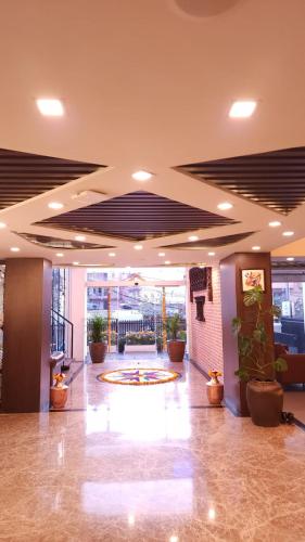 een lobby met een grote lobby met potplanten bij Prudential Hotel Nepal in Kathmandu