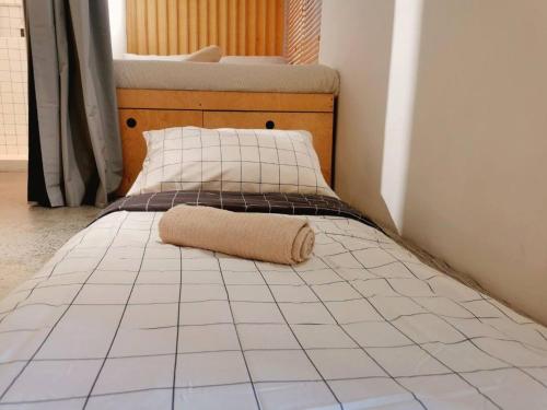 a bed with a towel on it in a room at HomeBase Apartment Hotel in Manila