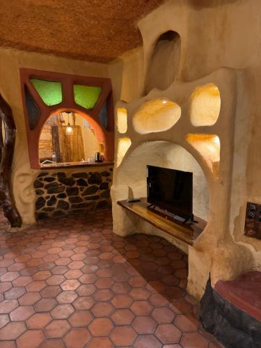 a living room with a flat screen tv in a stone wall at Udaya Resort in Palakkad