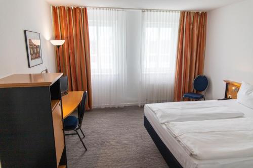 a hotel room with a bed and a desk at Hotel am Südtor in Backnang