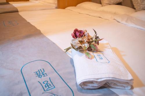 eine Blume auf einem Handtuch auf einem Bett in der Unterkunft 桜の川7 Asakusa 901 Kuramae train 3mins Free WiFi Eight people quiet,cook,perfect facilities in Tokio