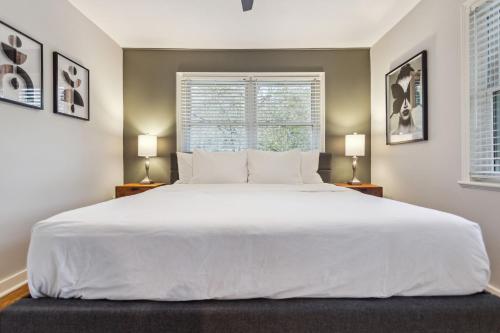 a large white bed in a bedroom with two lamps at Spacious 4BR Retreat in Vibrant Smyrna Near Lakes in Smyrna