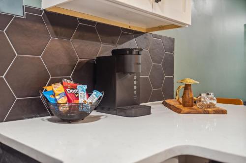 a counter top with a bowl of chips and a coffee maker at Spacious 4BR Retreat in Vibrant Smyrna Near Lakes in Smyrna