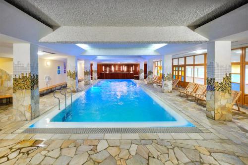 a large swimming pool in a hotel lobby at Bungalows Rogla in Zreče
