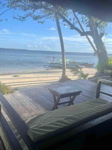 a picnic table and a bench on the beach at Angelito's Beach House Siargao near Beach in General Luna
