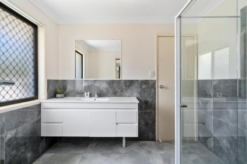 uma casa de banho com um lavatório branco e um chuveiro em Econo Lodge Waterford em Loganlea