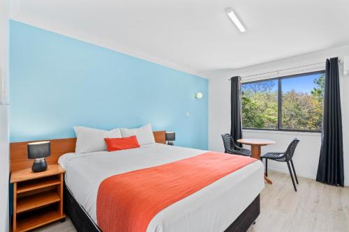 a bedroom with a large bed and a window at Econo Lodge Waterford in Loganlea