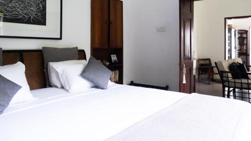 a bedroom with a white bed with white pillows at "27" Spathodea- Oasis in the City in Colombo