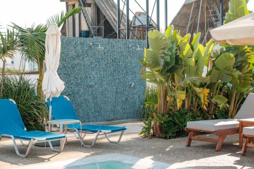 a group of chairs and an umbrella next to a pool at Kapetanios Bay Hotel Protaras in Protaras
